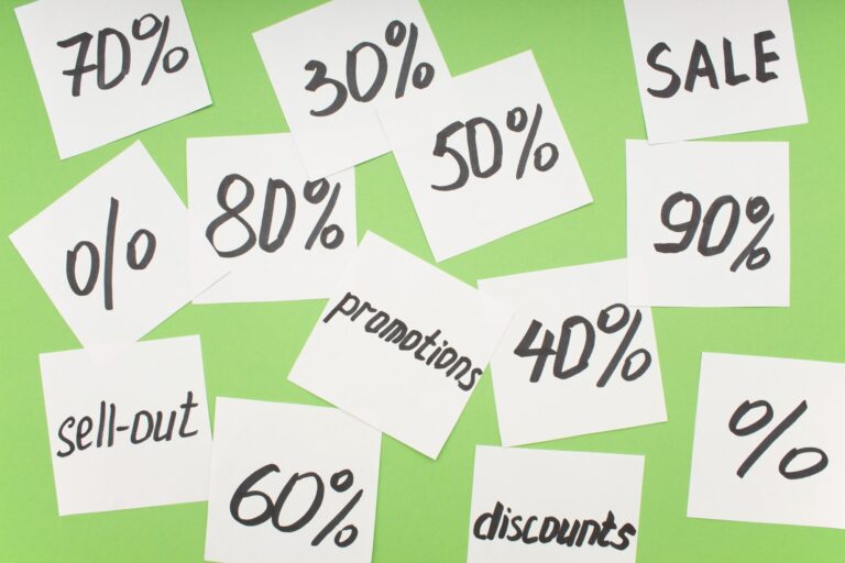 white stickers with inscriptions about discounts are chaotically scattered on a green background